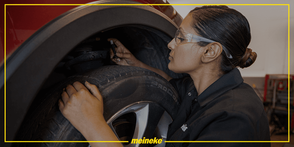 A mechanic checking the tread of a tire